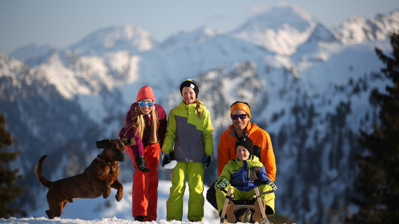 Family with dog and toboggan on the winter hiking trail. | © Gregor Hartl